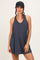 woman wearing a navy blue sleeveless dress with a v-neck and side pocket, styled with a black cap