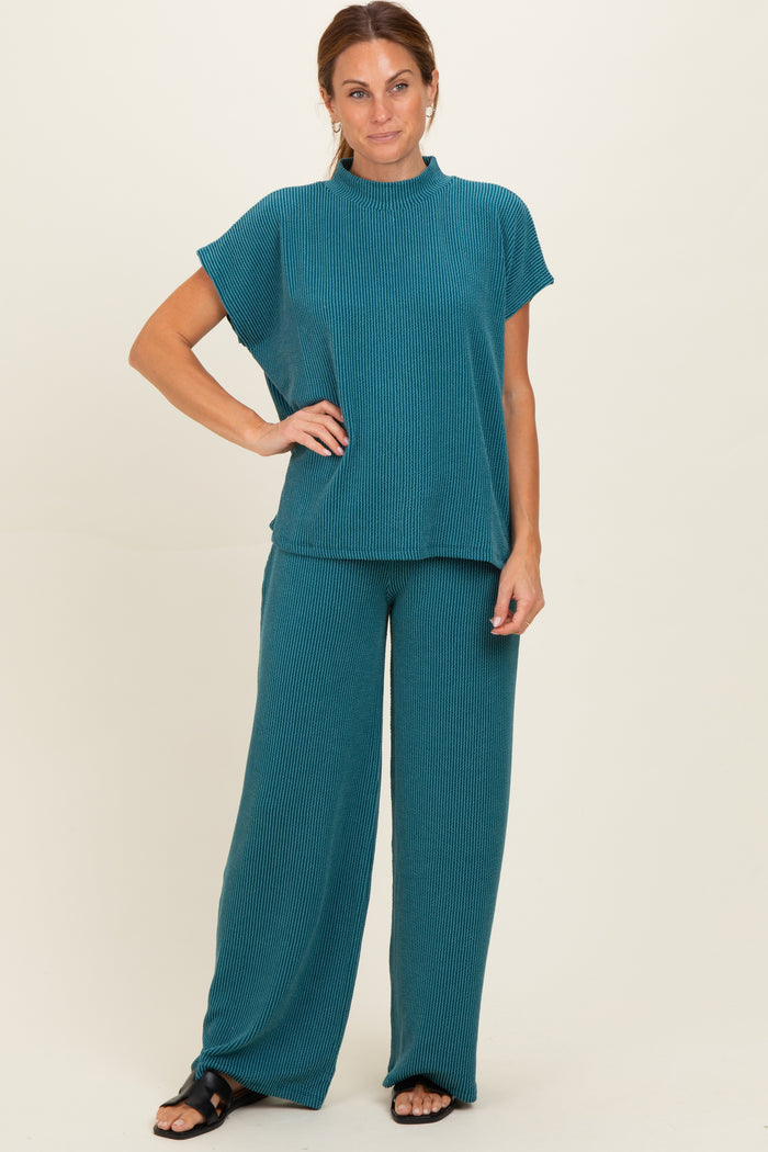 woman wearing a teal ribbed two-piece lounge set with a short sleeve top and wide-leg pants