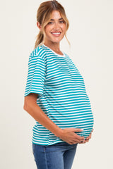 woman wearing a turquoise and white striped maternity top and holding her baby bump