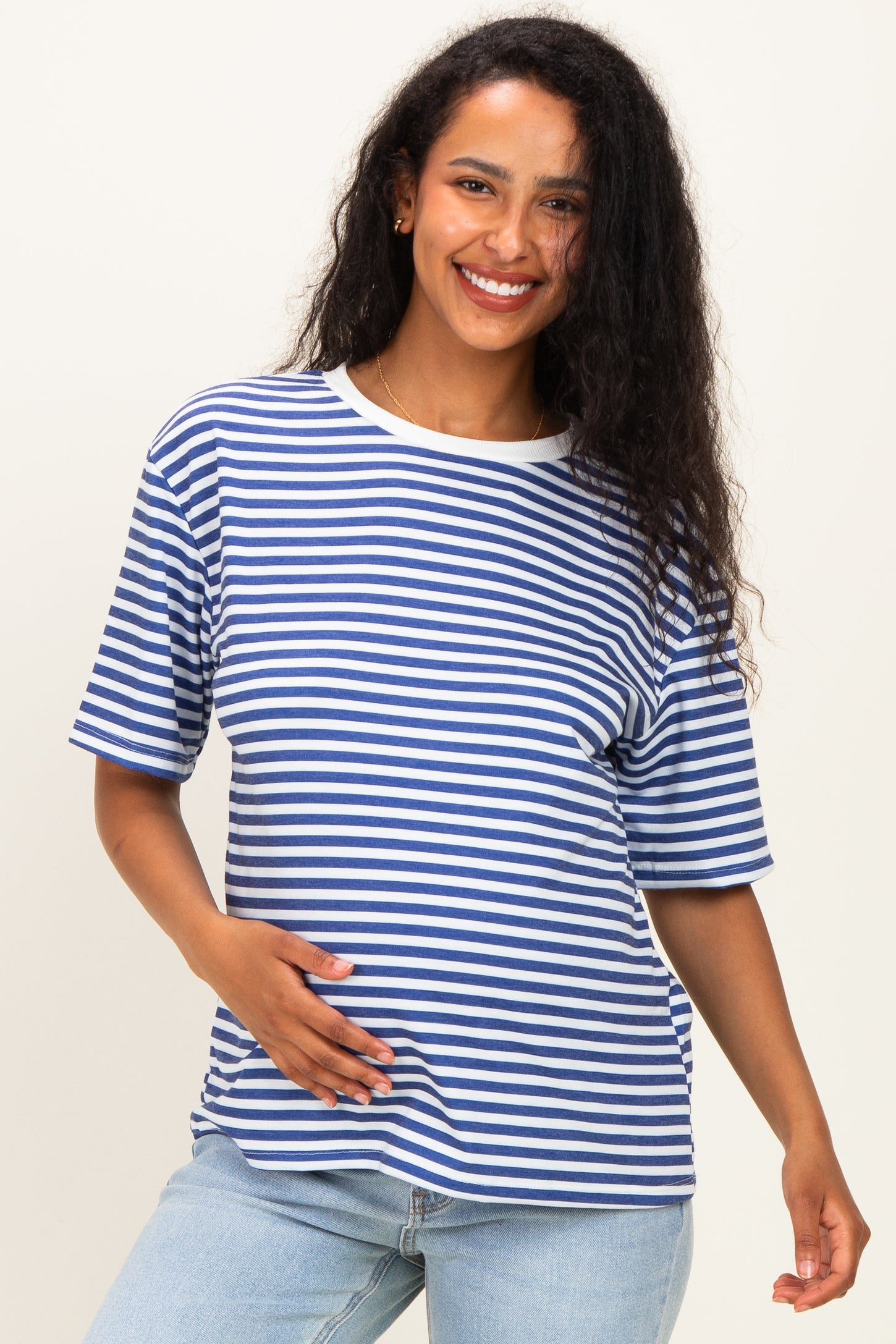 woman wearing a navy and white striped maternity t-shirt and holding her baby bump