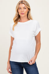 woman wearing a white maternity top with rolled sleeves and a visible baby bump