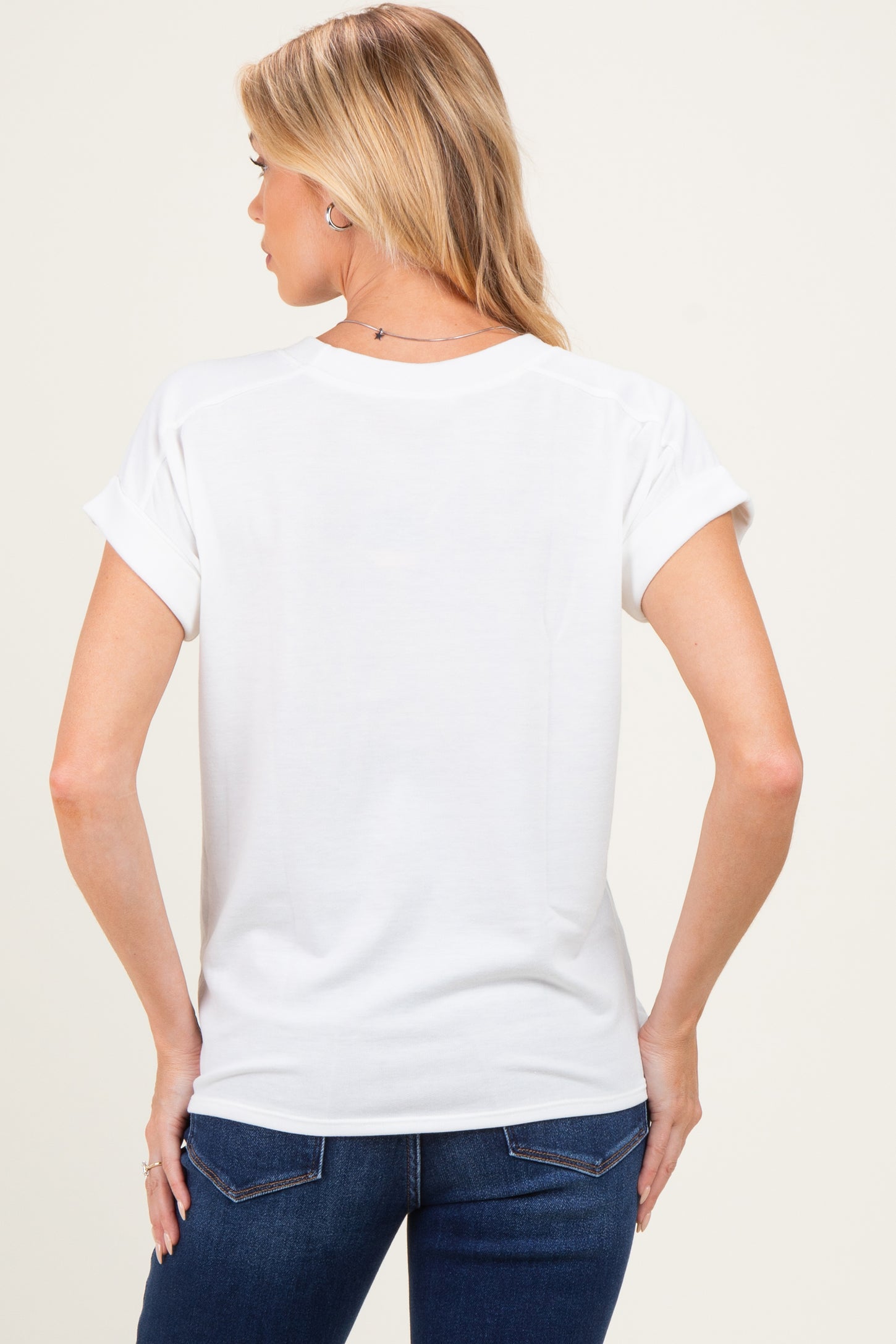 woman wearing a white short sleeve maternity top with rolled cuffs, viewed from the back