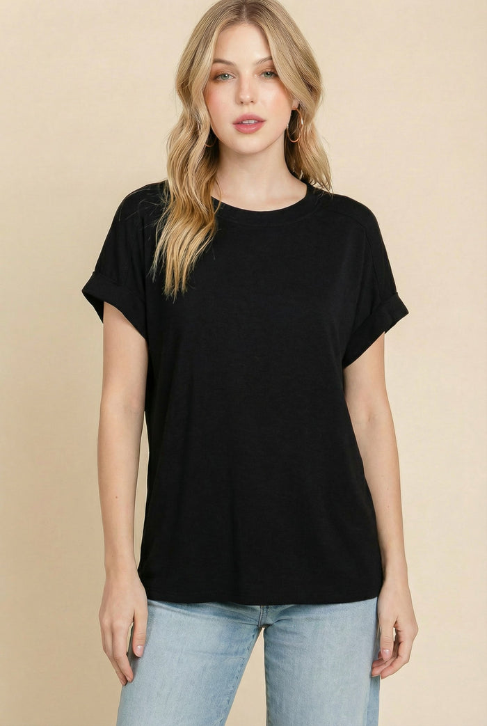 woman wearing a black short sleeve t-shirt with rolled cuffs and relaxed fit, paired with light blue jeans