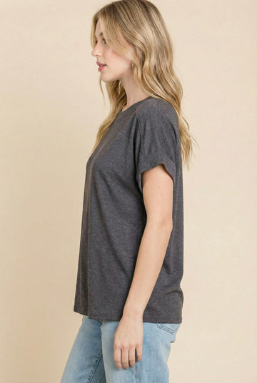 woman wearing a charcoal gray short sleeve t-shirt with rolled sleeves and relaxed fit, paired with light blue jeans