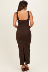 woman wearing a brown maternity maxi dress with a scoop back and side slit, showing her baby bump