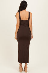 woman wearing a brown sleeveless form-fitting maxi dress with a split at the back