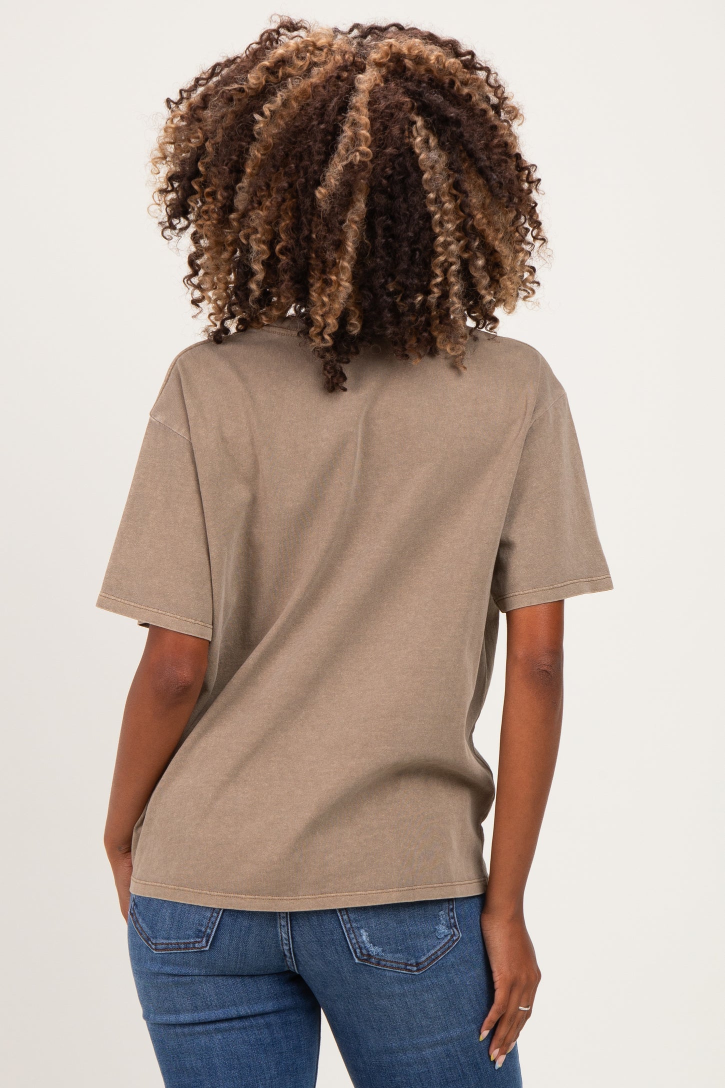 woman wearing a taupe oversized maternity t-shirt and blue jeans, showing the back view