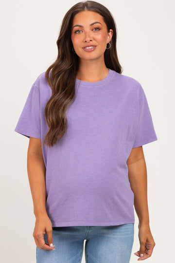 woman wearing a purple short sleeve maternity t-shirt and blue jeans with a visible baby bump
