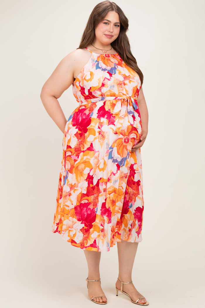 woman wearing a floral maternity plus dress with an empire waist and pockets, showcasing her baby bump