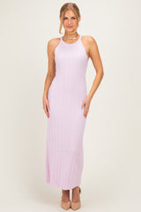 woman wearing a light pink ribbed maxi dress with a halter neck and fitted style