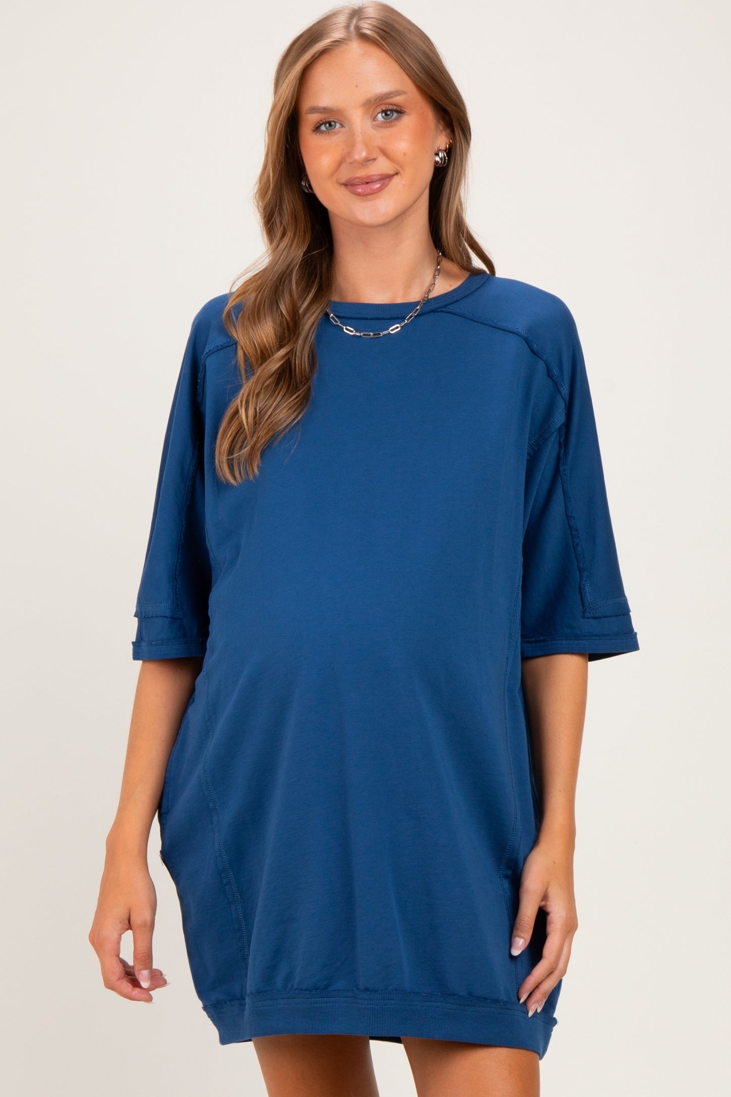 woman wearing a navy blue maternity dress with short sleeves and a relaxed fit, showcasing a baby bump