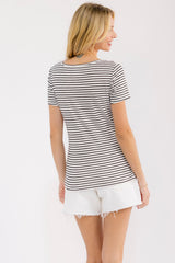 woman wearing a striped short sleeve t-shirt with a fitted style, paired with white distressed denim shorts