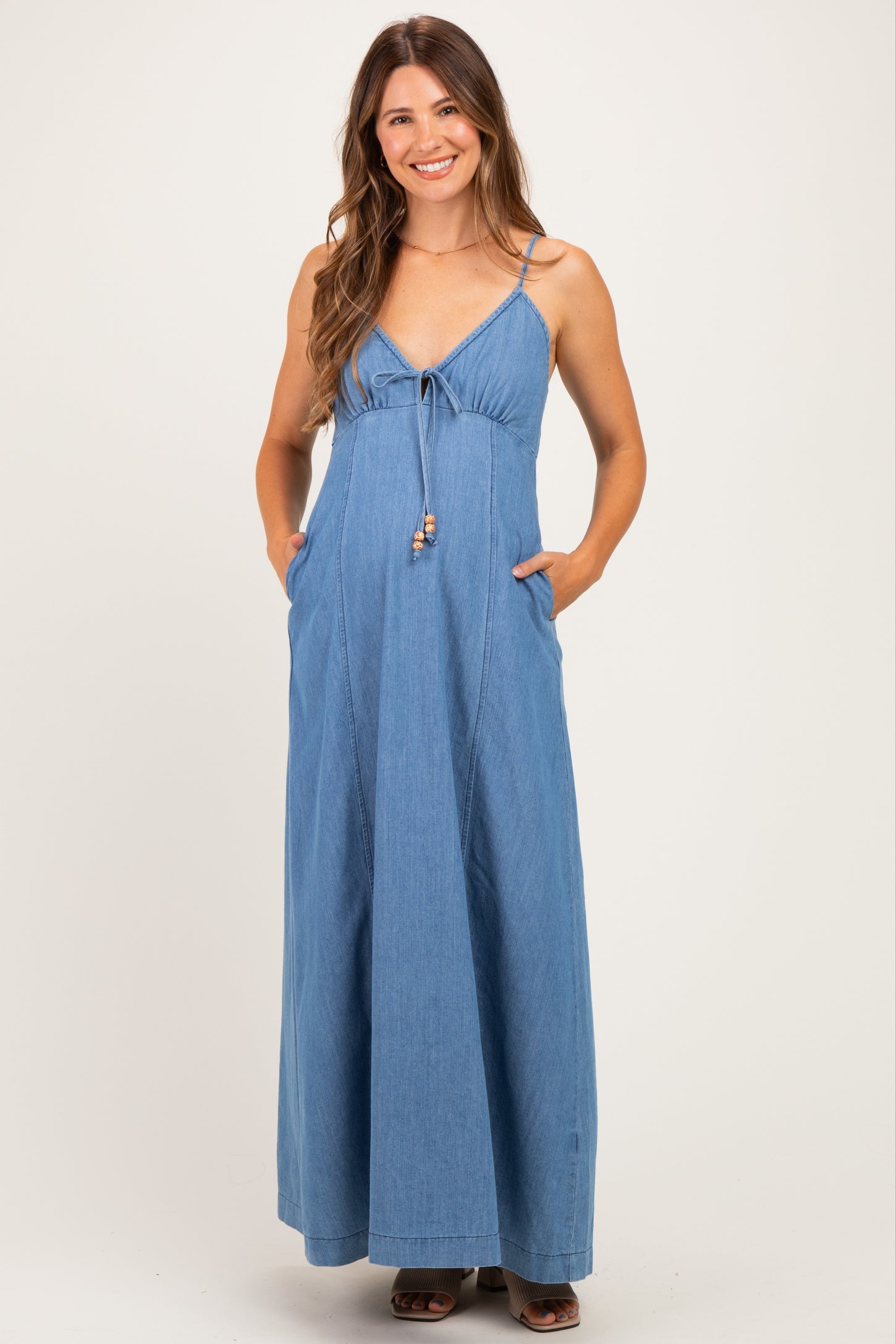 woman wearing a light blue maternity maxi dress with adjustable spaghetti straps and pockets