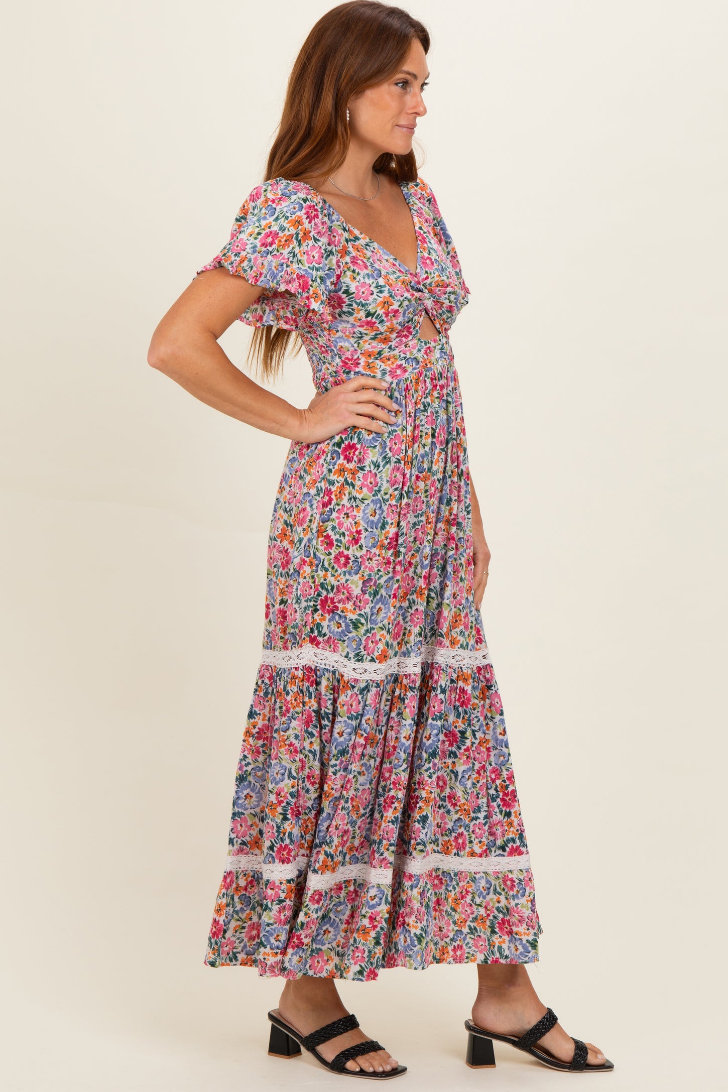 woman wearing a floral patterned maxi dress with short flutter sleeves and a tiered skirt