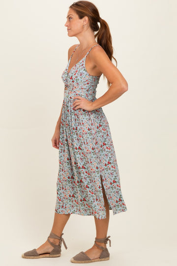 woman wearing a floral print midi dress with a deep v-neck and side slits, styled with espadrille sandals