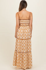 woman wearing a floral print maternity maxi dress with spaghetti straps and a tiered design, showing a baby bump