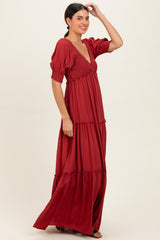 woman wearing a rust red maxi dress with puff sleeves and tiered detailing