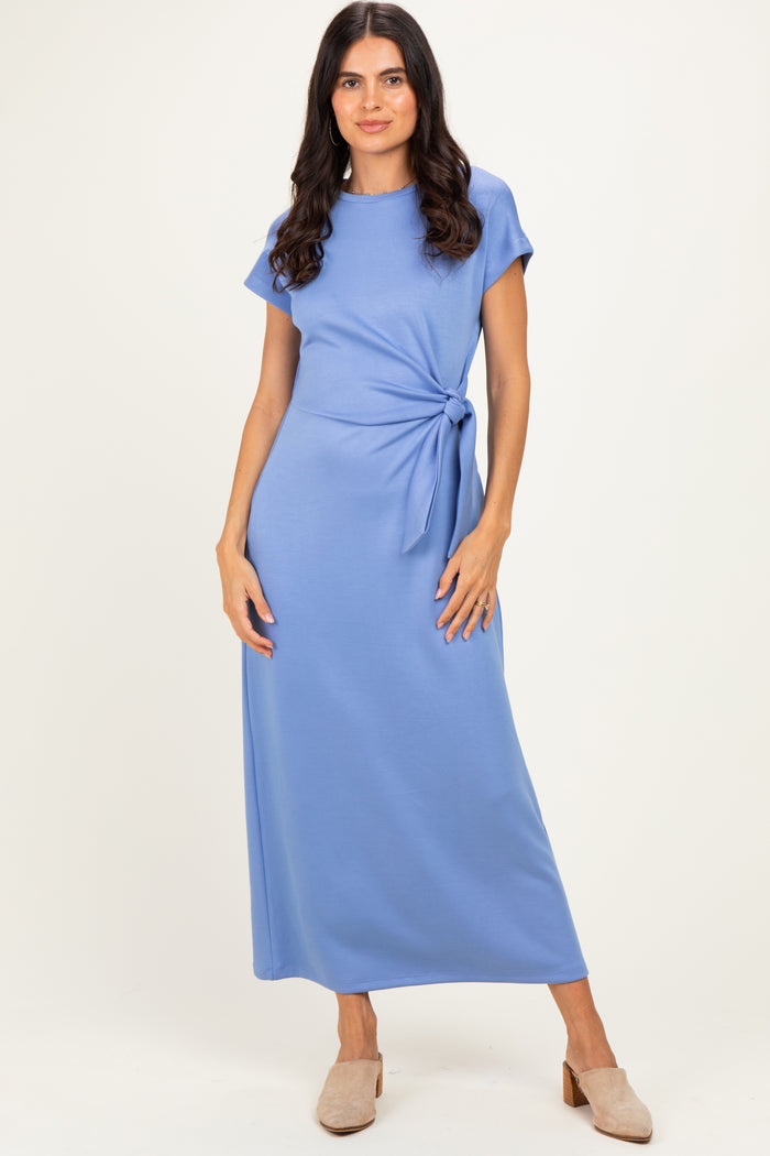 woman wearing a light blue maxi dress with short sleeves and a side tie detail
