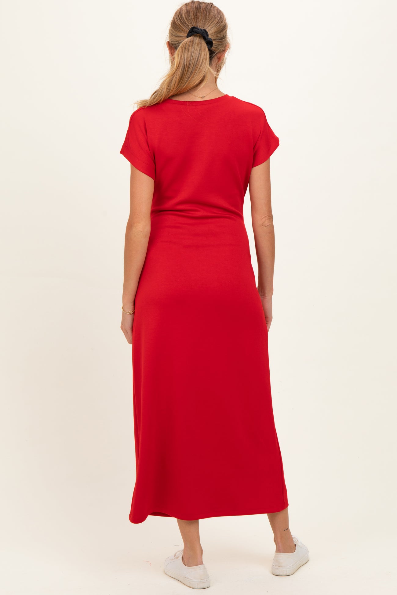 woman wearing a red maternity maxi dress from the back with short sleeves and a fitted silhouette