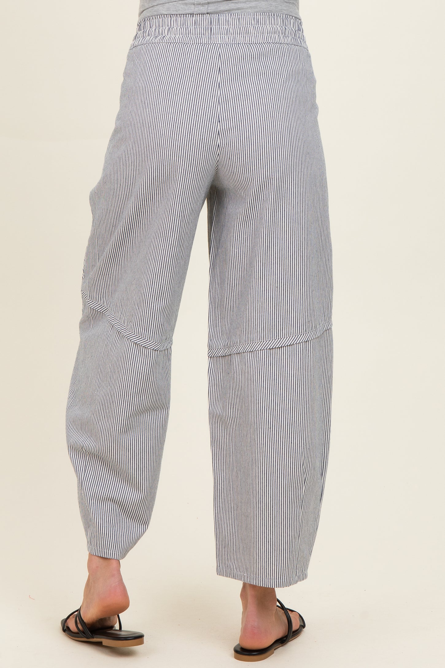 woman wearing striped maternity pants with a relaxed fit and elastic waistband, viewed from the back