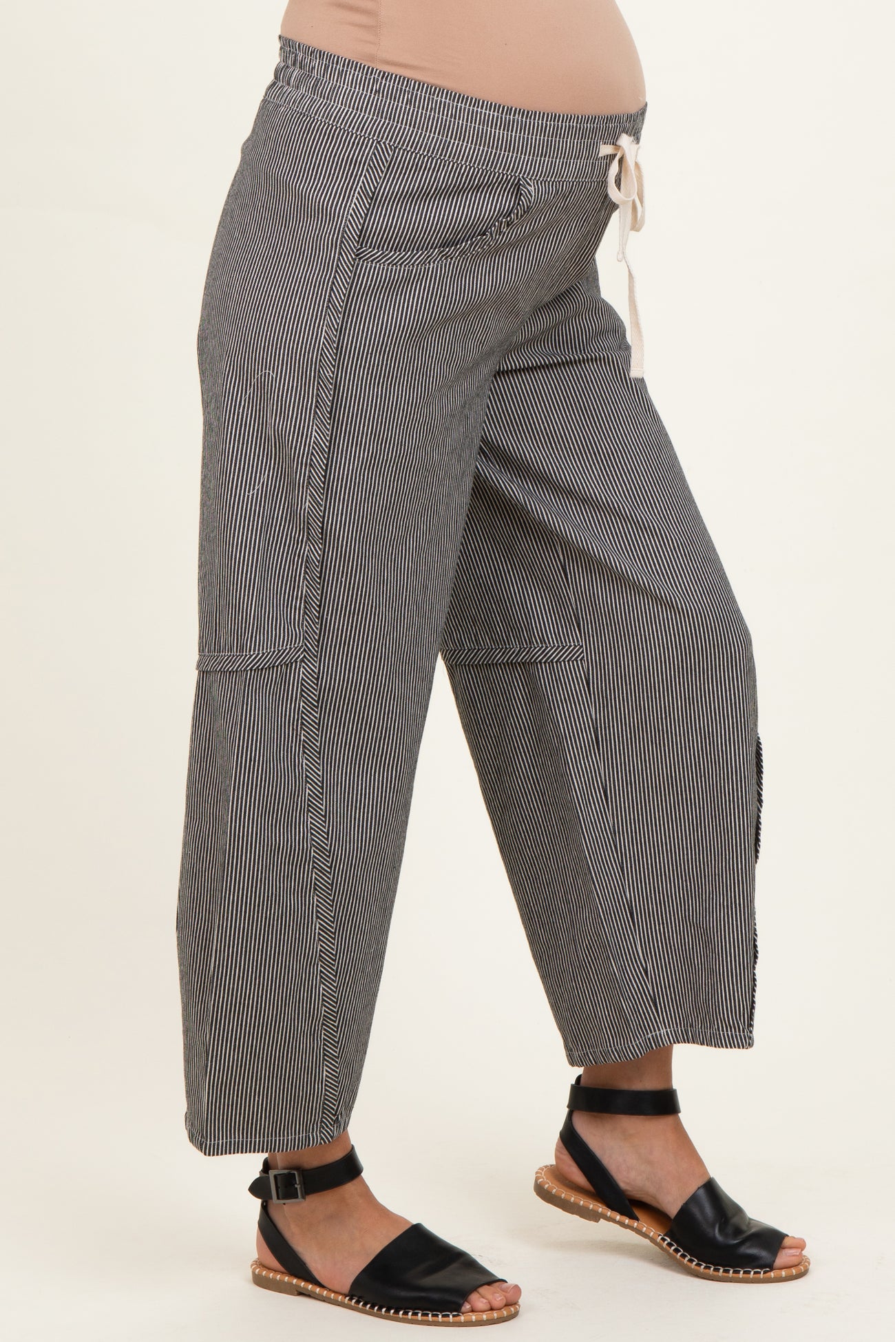 woman wearing black and white striped maternity wide-leg pants with a drawstring waist and visible baby bump