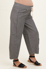 woman wearing black and white striped maternity wide-leg pants with a drawstring waist and visible baby bump