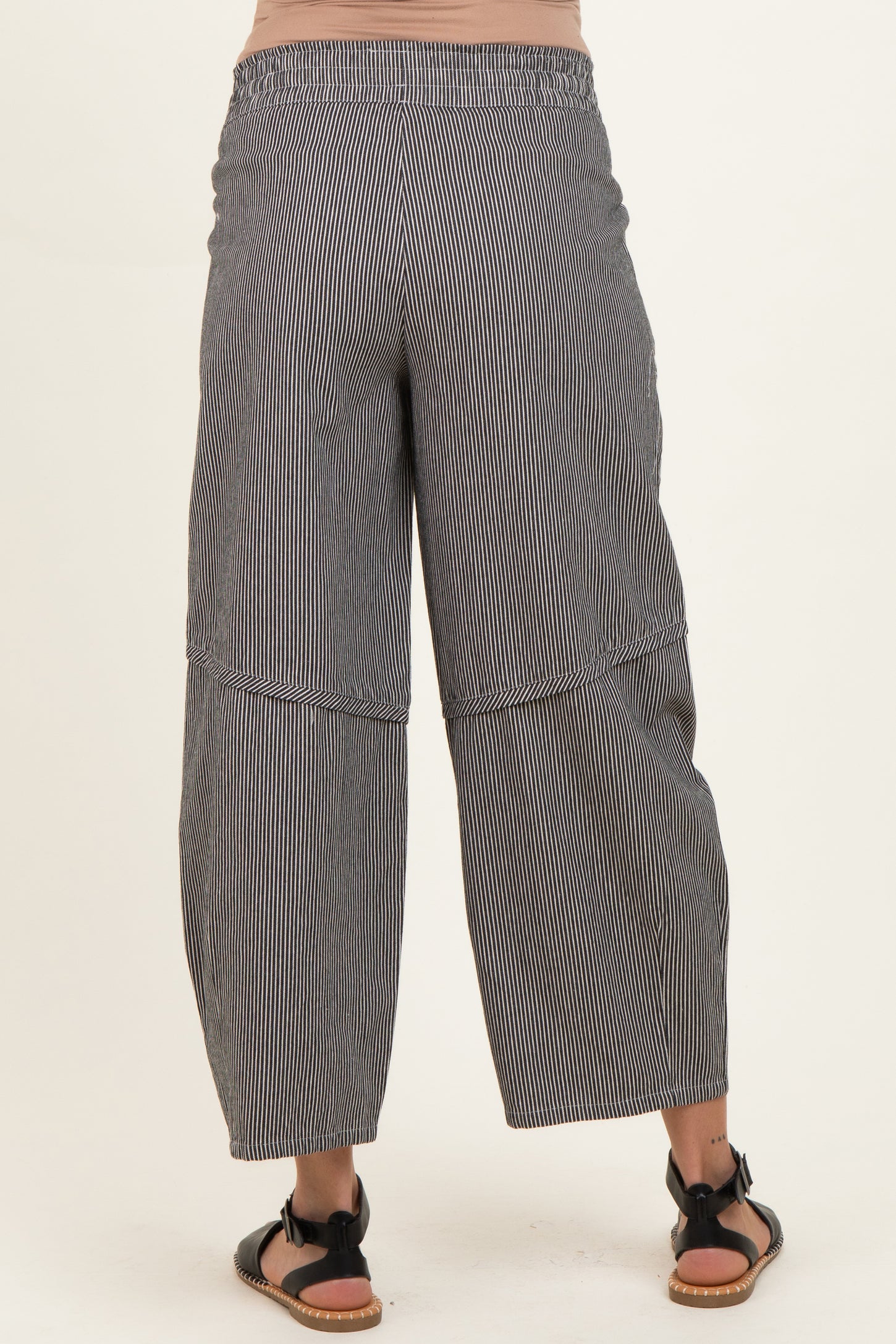 woman wearing black and white striped maternity wide-leg pants, viewed from the back
