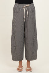woman wearing black and white striped wide-leg pants with an elastic waistband and drawstring detail