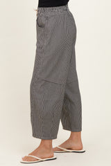 woman wearing black and white striped wide-leg pants with an elastic waistband and side pockets