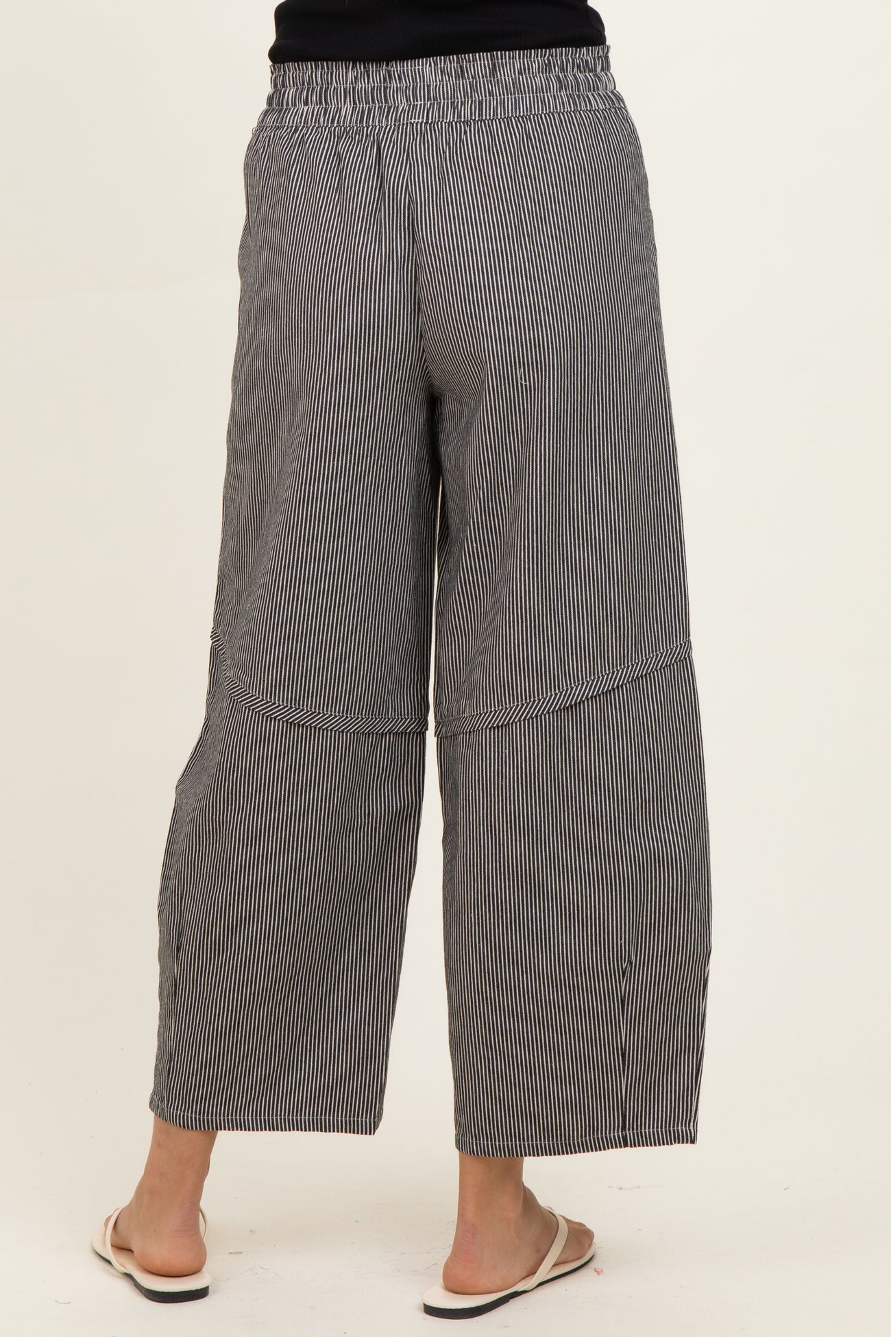 woman wearing black and white striped wide-leg culottes with an elastic waistband, viewed from the back