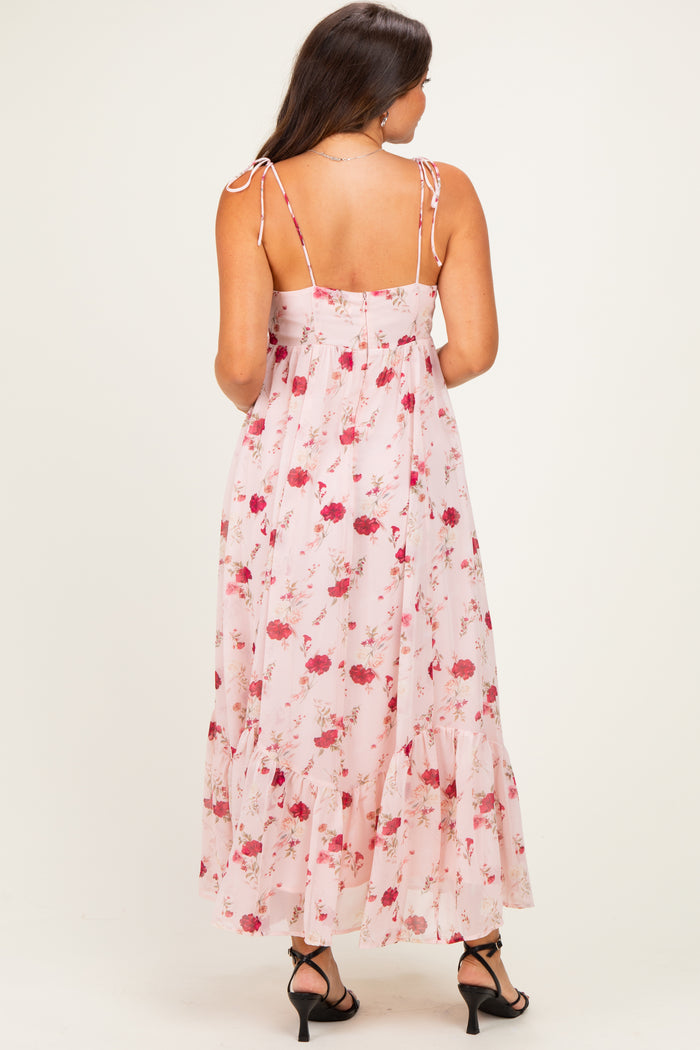 woman wearing a pink floral maternity maxi dress with back ties and ruffle hem
