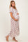 woman wearing a floral maternity maxi dress and holding her baby bump
