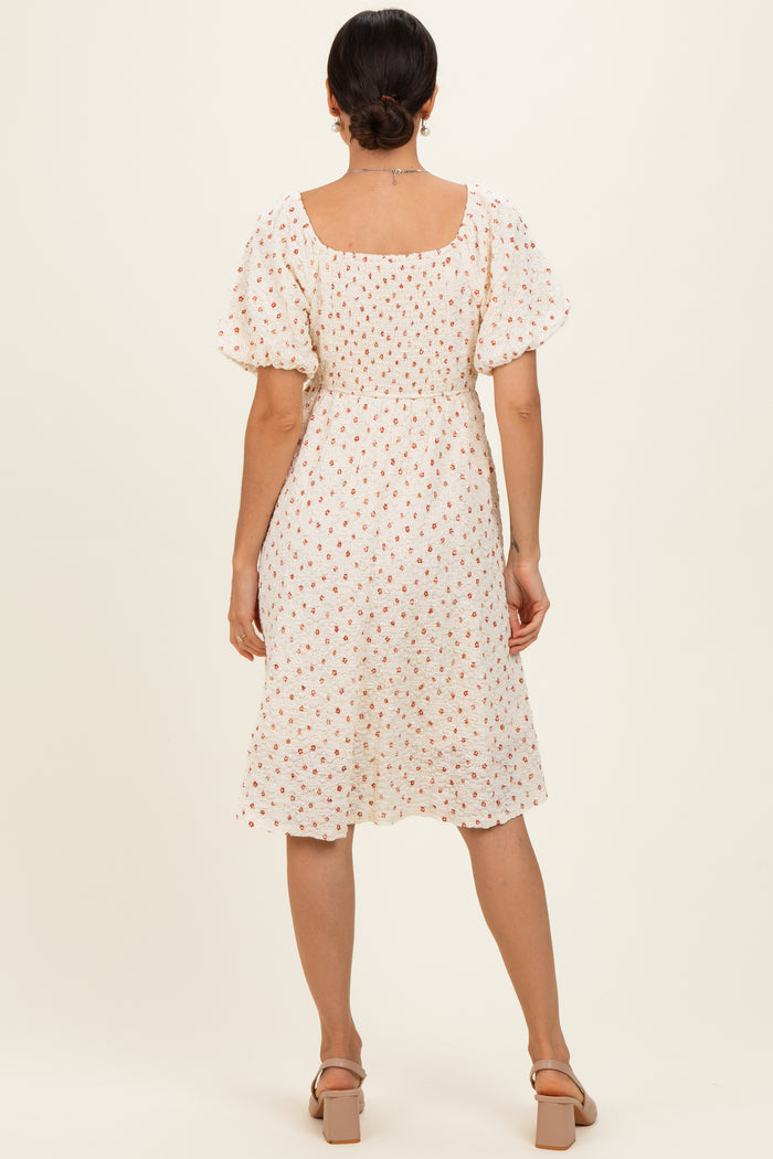 woman wearing a white floral midi dress with puff sleeves and a square neckline, shown from the back
