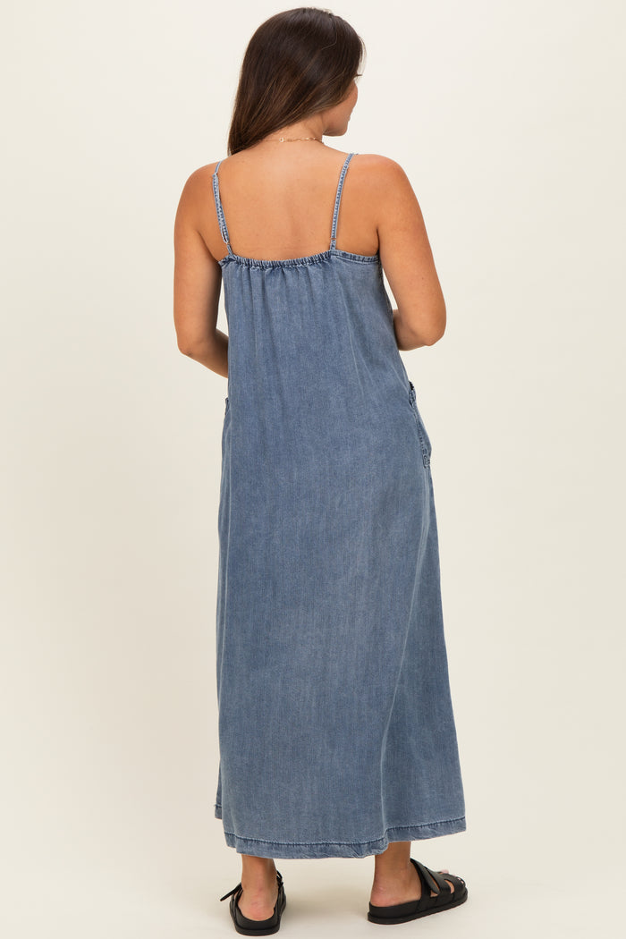 woman wearing a blue denim maxi maternity dress with adjustable straps, shown from the back