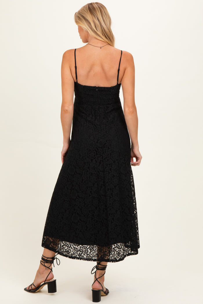 woman wearing a black lace maternity dress with adjustable straps and a flowy hem, showing support for a baby bump