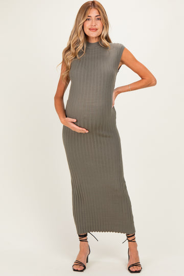 woman wearing a fitted olive green maternity dress with ribbed detailing and holding her baby bump