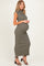 woman wearing a dark green sleeveless ribbed maternity dress and holding her baby bump