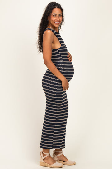 woman wearing a navy and cream striped sleeveless maternity dress, showcasing her baby bump