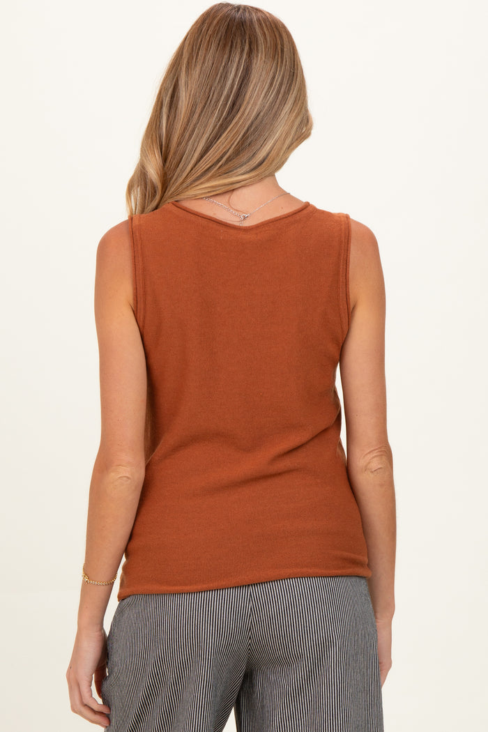 woman wearing a rust orange maternity tank top, view shows the back of the top