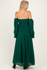 woman wearing a green off-the-shoulder maxi dress with long puff sleeves and lace detailing, shown from the back