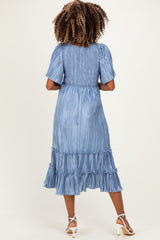 woman wearing a light blue pleated maternity dress with ruffle hem and short sleeves, showing her back