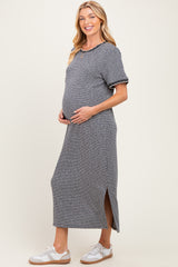 woman wearing a navy and white striped maternity dress with short sleeves and side slits, showing her baby bump