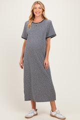 woman wearing a striped maternity maxi dress with short sleeves and a scalloped neckline, displaying her baby bump