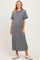 woman wearing a striped maternity maxi dress with short sleeves and a scalloped neckline, displaying her baby bump