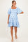 woman wearing a light blue maternity dress with floral embroidery and short puff sleeves, holding a white handbag