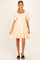 woman wearing a cream floral maternity dress with puff sleeves and ruffled hem