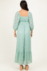 woman wearing a mint green lace maxi dress with balloon sleeves and a ruffled hem, viewed from the back