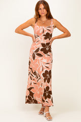 woman wearing a pink and brown floral maxi dress with a fitted bodice and flowing skirt