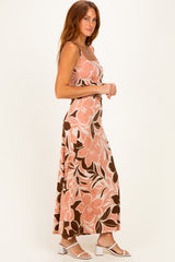 woman wearing a pink floral maxi dress with spaghetti straps and a flowy design, standing sideways