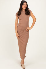 woman wearing a fitted beige maxi dress with short sleeves and a sleek silhouette
